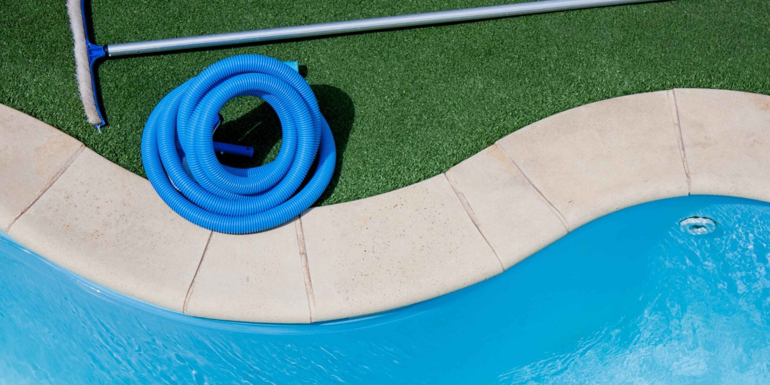 Pool maintenance tools including a vacuum hose and brush used for routine pool cleaning